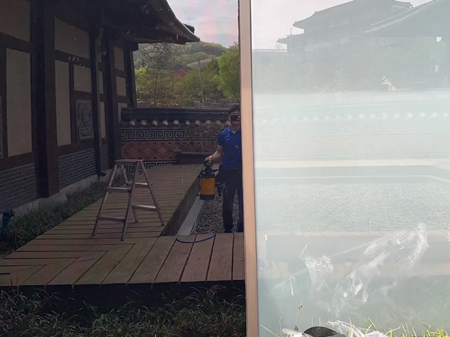 전문 기사가 회랑 창문에 시공액을 분사하는 작업 모습