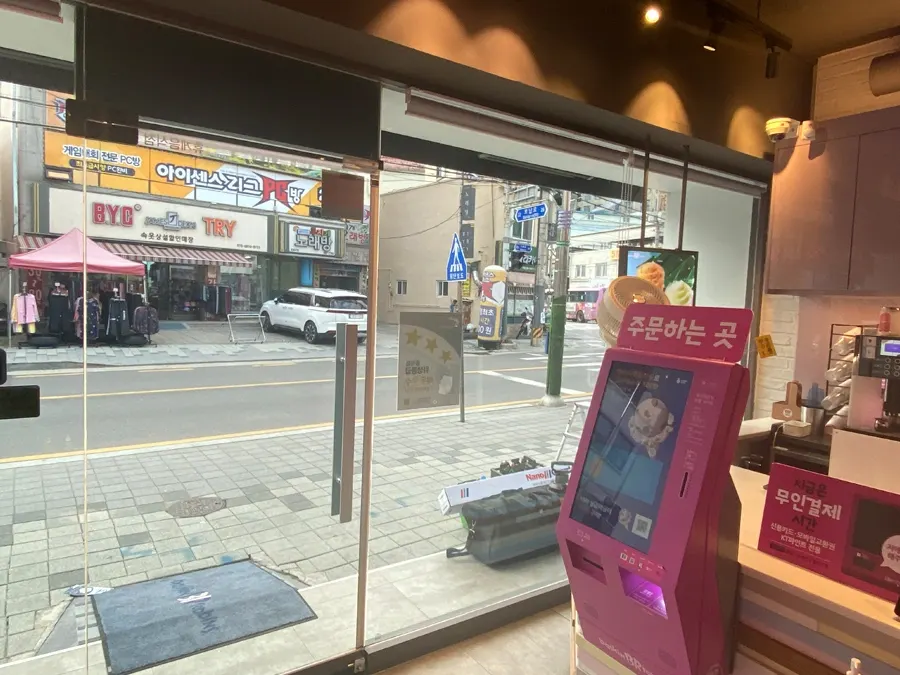 시공 전 무인 주문 키오스크 옆 통유리창, 외부 도로가 선명하게 보이는 상태